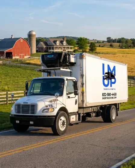 An IM UP refrigerated logistics truck parked at a Texas farm during harvest season, ready to load fresh agricultural yield.